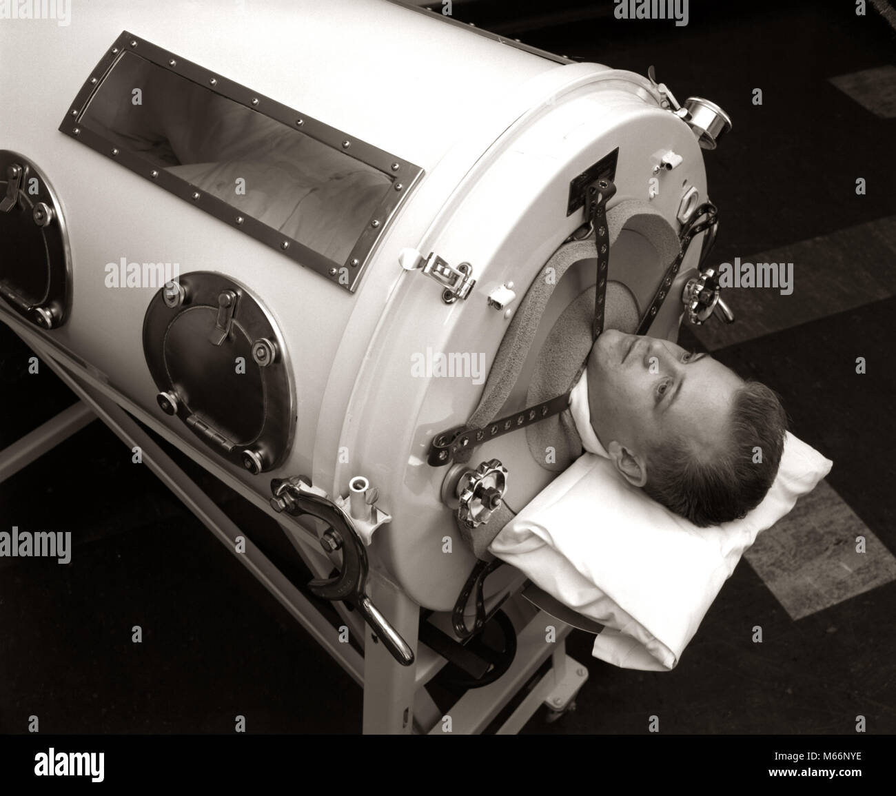1930s 1940s 1950s MAN LYING IN IRON LUNG NEGATIVE PRESSURE VENTILATOR ARTIFICIAL BREATHING MACHINE - m6513 HAR001 HARS CARING RISK INDOORS PROFESSION CONFIDENCE NOSTALGIA SADNESS HEALTHCARE HISTORIC SINGLE OBJECT OCCUPATION WELLNESS HEAD AND SHOULDERS BREATHING PROTECTION COURAGE OCCASION HEALTH CARE SUPPORT GOOD HEALTH ESCAPE HOSPITALS FACILITY FACILITIES POLIO POLIOMYELITIS RESPIRATORY RESPIRATORY DISEASE LAY MALES MID-ADULT MID-ADULT MAN ARTIFICIAL B&W BLACK AND WHITE CAUCASIAN ETHNICITY DISEASE FERROUS METAL HOSPITALIZATION IRON LUNG LUNG MECHANICAL RESPIRATOR NEGATIVE PRESSURE VENTILATOR Stock Photo