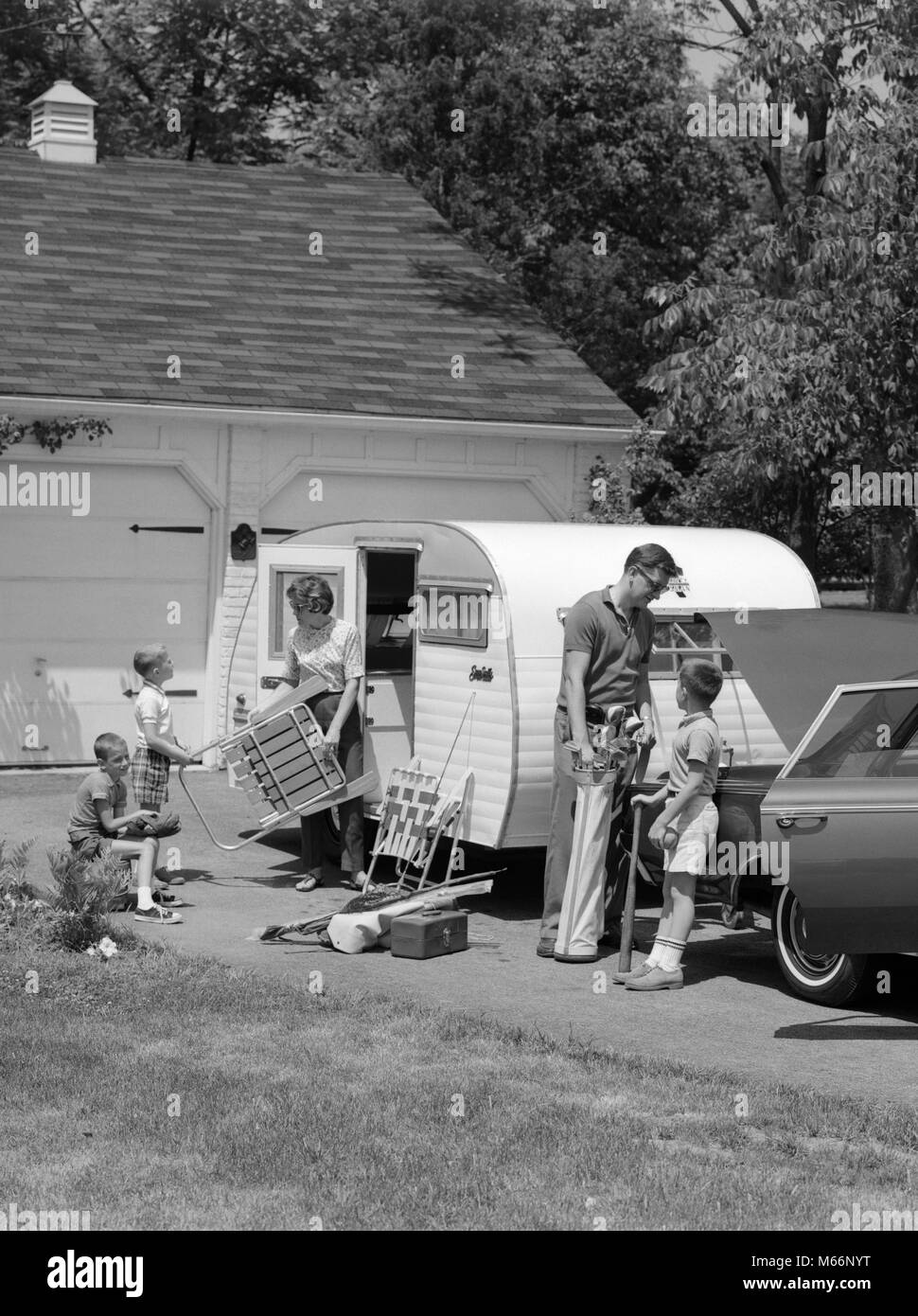 1960s FAMILY OF FIVE LOADING LAWN CHAIRS SPORTS EQUIPMENT INTO CAR TRAILER DRIVEWAY - m7032 HAR001 HARS AUTO JUVENILE MOTOR SAFETY TEAMWORK CAUCASIAN SONS LIFESTYLE PARENTING FEMALES 5 BROTHERS RELATION HUSBANDS HOME LIFE COPY SPACE FRIENDSHIP HALF-LENGTH AUTOMOBILE SIBLINGS TRANSPORTATION FAMILIES NOSTALGIA FATHERS HUSBAND AND WIFE TOGETHERNESS HUSBANDS AND WIVES LOADING WIVES ADVENTURE MOMS PARENTHOOD AND AUTOS DADS EXCITEMENT RECREATION PARENTAL AUTOMOTIVE MOTORING RELATIONSHIPS SIBLING COOPERATION AUTOMOBILES ESCAPE SMALL GROUP OF PEOPLE JUVENILES MALES MID-ADULT MID-ADULT MAN Stock Photo