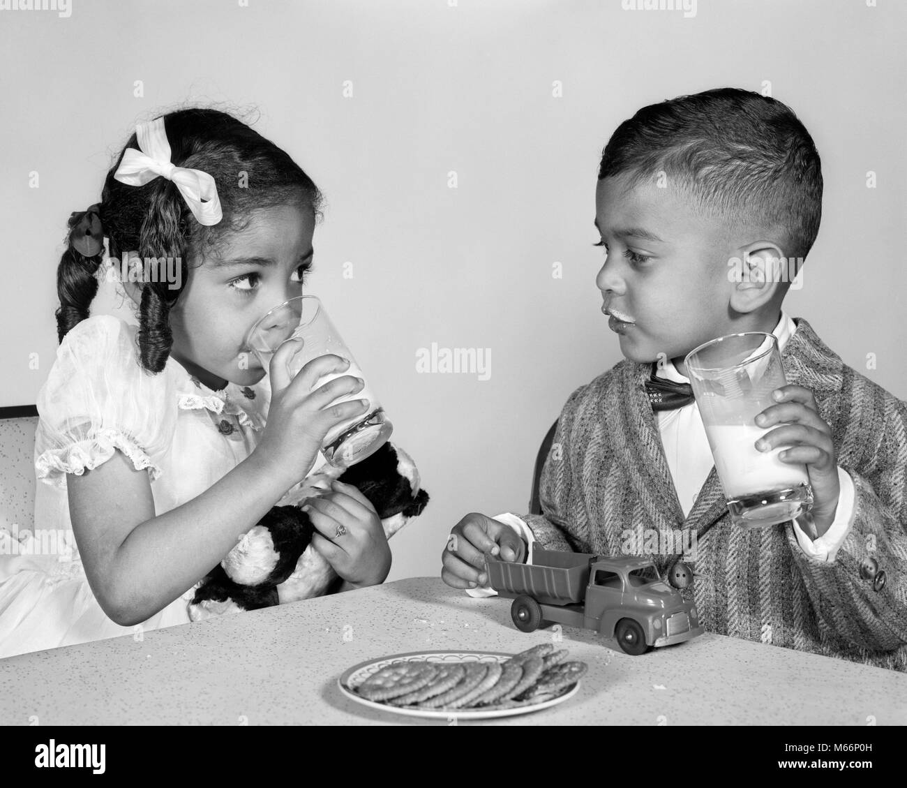 1960s AFRICAN AMERICAN GIRL BOY DRINKING MILK EATING COOKIES - n1761 HAR001 HARS SIBLINGS SISTERS NOSTALGIA TOGETHERNESS 3-4 YEARS 5-6 YEARS AFRICAN-AMERICANS AFRICAN-AMERICAN AFRICAN AMERICANS AFRICAN AMERICAN GROWTH SIBLING AFTER SCHOOL JUVENILES MALES B&W BLACK AND WHITE MILK AND COOKIES OLD FASHIONED Stock Photo
