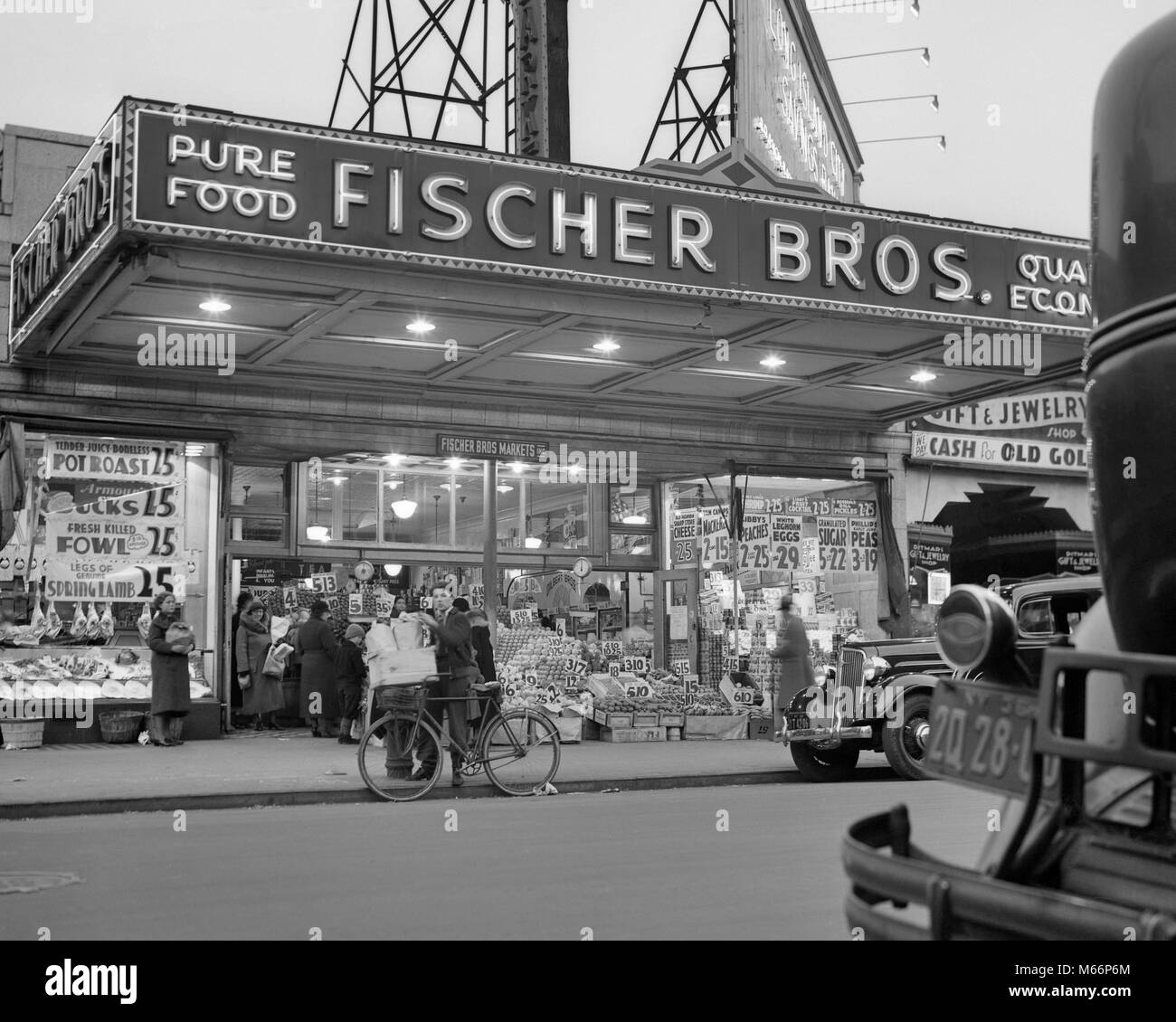 1930s DISPLAY OF FOODS WITH PRICES FRONT OF GROCERY STORE ASTORIA QUEENS NEW YORK CITY USA - q49645 CPC001 HARS NYC STORES NEW YORK CITIES PRICES STOREFRONT GROUP OF PEOPLE NEW YORK CITY BOROUGH FACADE FENDER ASTORIA B&W BIG APPLE BLACK AND WHITE FISCHER OCCUPATIONS OLD FASHIONED PURE Stock Photo