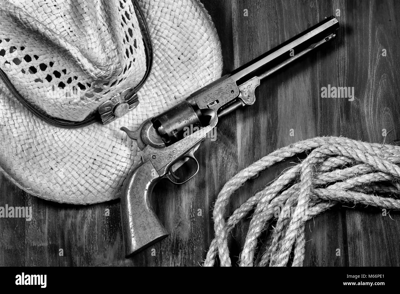 Old cowboy pistol ,straw hat and rope in black and white. Stock Photo