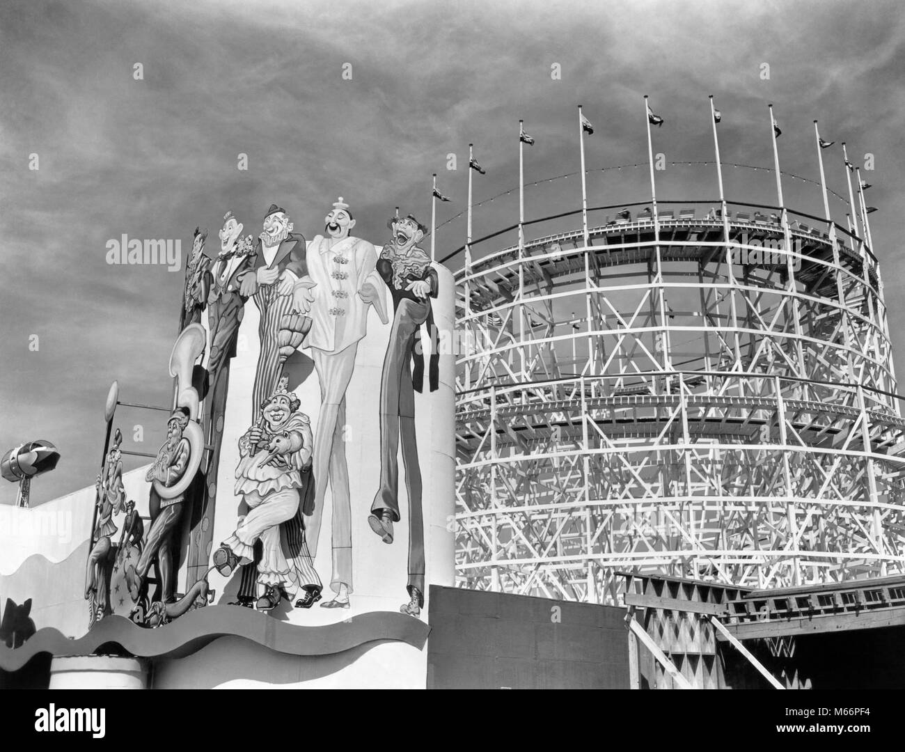 1930s 1939 WORLD'S FAIR CLOWN MURAL AND ROLLER COASTER IN AMUSEMENT AREA NEW YORK CITY NY USA - r1396 PAL001 HARS B&W BLACK AND WHITE CORONA PARK EXPO EXPOSITION FLUSHING MEADOW MURAL OLD FASHIONED ROLLER COASTER Stock Photo