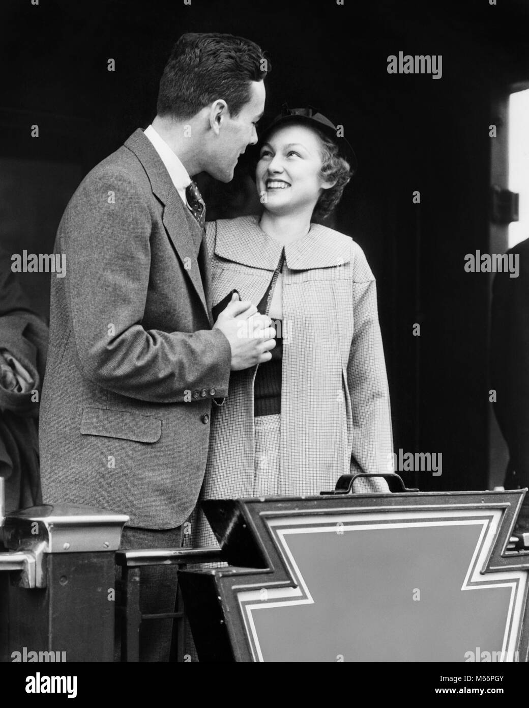 1930s SMILING COUPLE MAN WOMAN HOLDING HANDS STANDING ON REAR PLATFORM OF TRAIN OBSERVATION CAR - r6017 HAR001 HARS RAILROAD PLEASED JOY LIFESTYLE CELEBRATION FEMALES HUSBANDS HEALTHINESS LUXURY COPY SPACE FRIENDSHIP HALF-LENGTH LADIES CARING COUPLES TRANSPORTATION NOSTALGIA TOGETHERNESS 20-25 YEARS 25-30 YEARS RAIL DREAMS PLATFORM WIVES HAPPINESS ADVENTURE STYLES TRIP EXCITEMENT 18-19 YEARS SMILES CONNECTION JOYFUL FASHIONS ESCAPE RAILROADS CABOOSE HONEYMOON MALES NEWLYWEDS YOUNG ADULT MAN YOUNG ADULT WOMAN B&W BLACK AND WHITE CAUCASIAN ETHNICITY OLD FASHIONED PERSONS Stock Photo