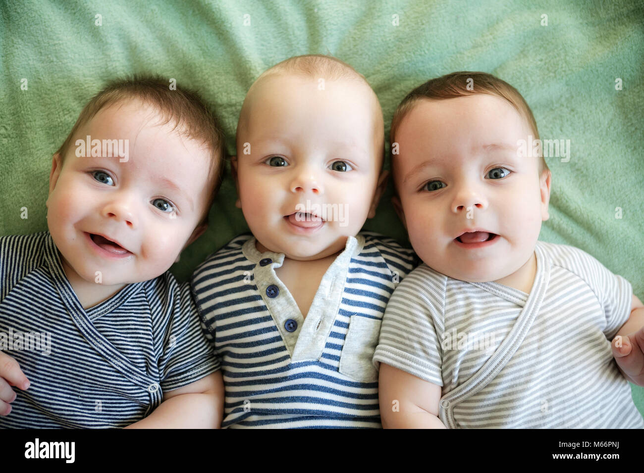 Portrait of newborn triplets are lying in the bed Stock Photo Alamy