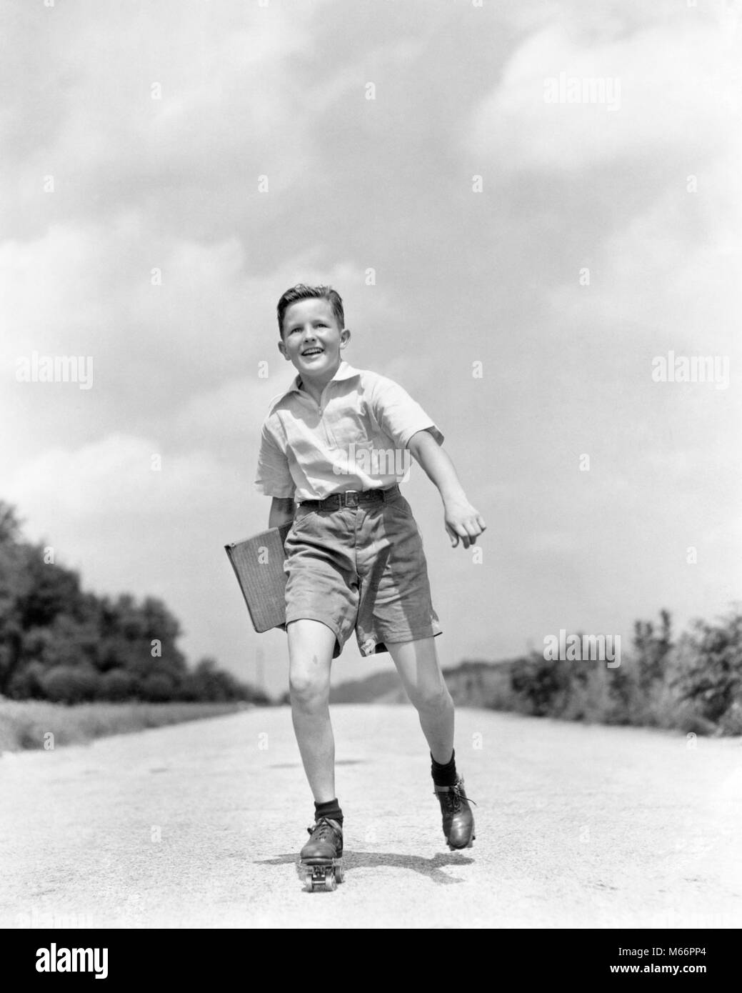1930s 1930s SMILING BOY ROLLER SKATING TO SCHOOL LOOKING AT CAMERA CARRYING TEXTBOOK BINDER - s780 HAR001 HARS COPY SPACE FULL-LENGTH PHYSICAL FITNESS CONFIDENCE TRANSPORTATION NOSTALGIA EYE CONTACT 10-12 YEARS 7-9 YEARS PRETEEN BOY ACTIVITY HAPPINESS CHEERFUL TEXTBOOK EXCITEMENT RECREATION PRIDE GROWTH SMILES JOYFUL SHORT PANTS SCHOOL BOOKS JUVENILES MALES PRE-TEEN PRE-TEEN BOY ROLLER SKATES B&W BINDER BLACK AND WHITE CAUCASIAN ETHNICITY LOOKING AT CAMERA METAL SKATES OLD FASHIONED Stock Photo