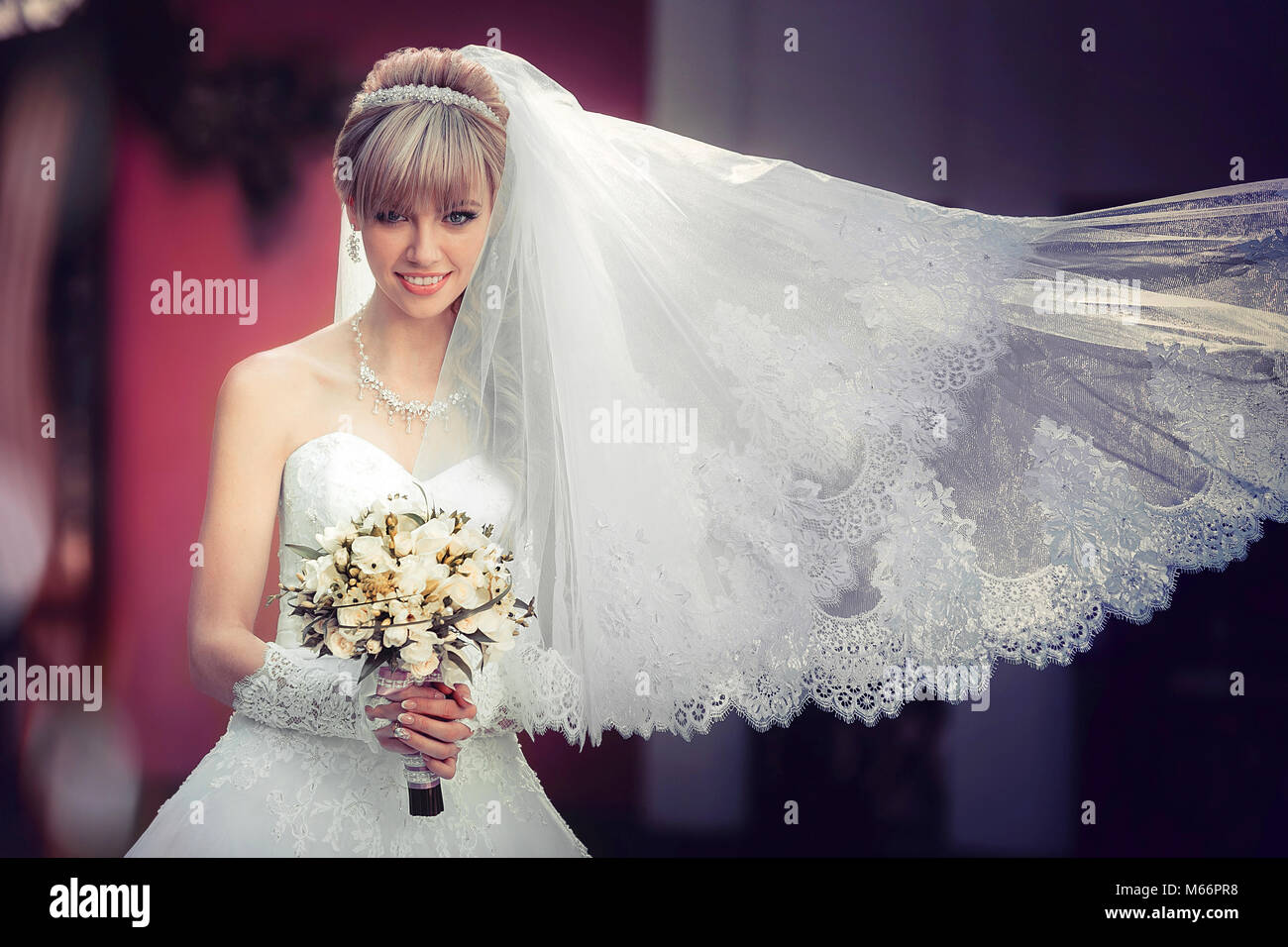 Portrait of a beautiful blonde bride with wedding bouquet in the hand ...