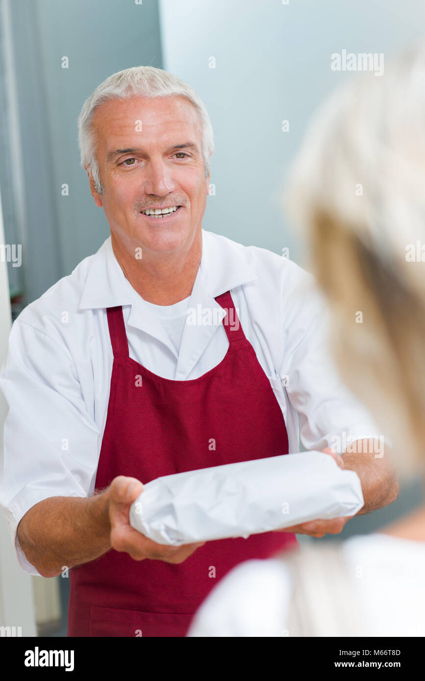 vendor handling wrapped product to customer Stock Photo Alamy