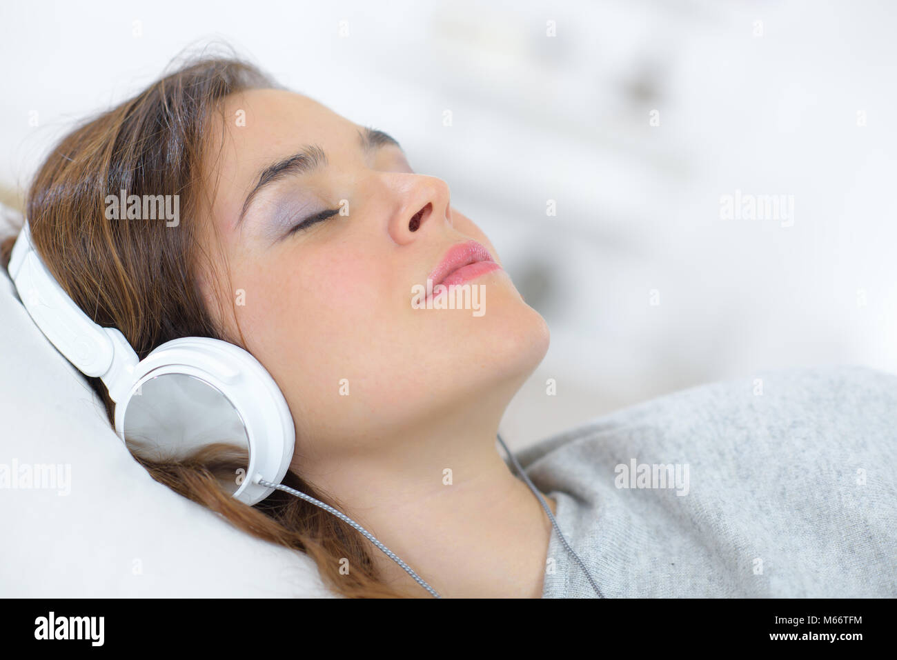 young beautiful woman headphones listening music on bed top view Stock Photo