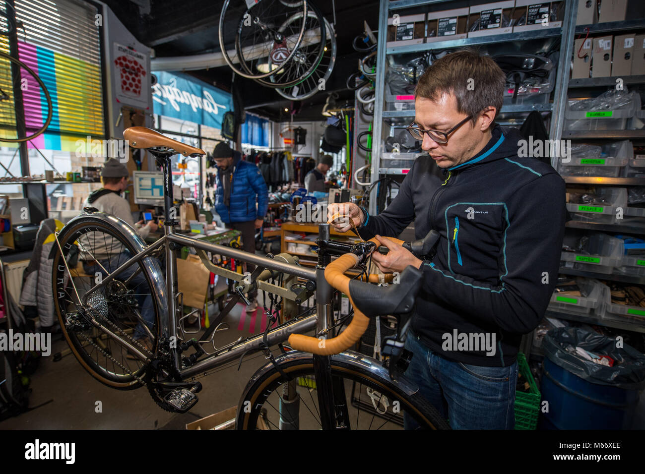 Man repairs bicycle, bike repair shop, Radcafe Schicke Mütze, Düsseldorf, North Rhine-Westphalia, Germany Stock Photo