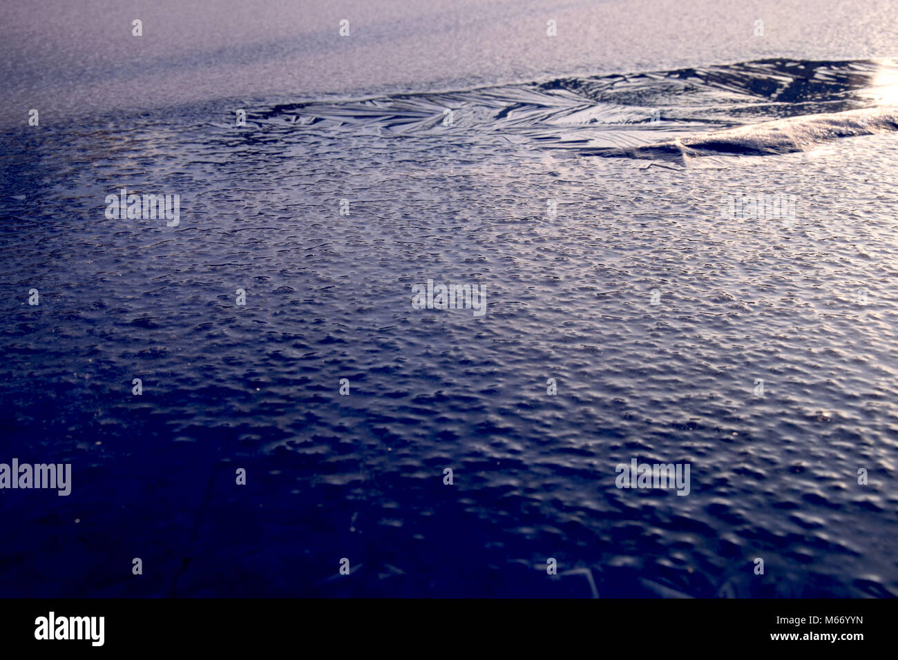 frozen structures on a lake with reflexions of sunlight Stock Photo