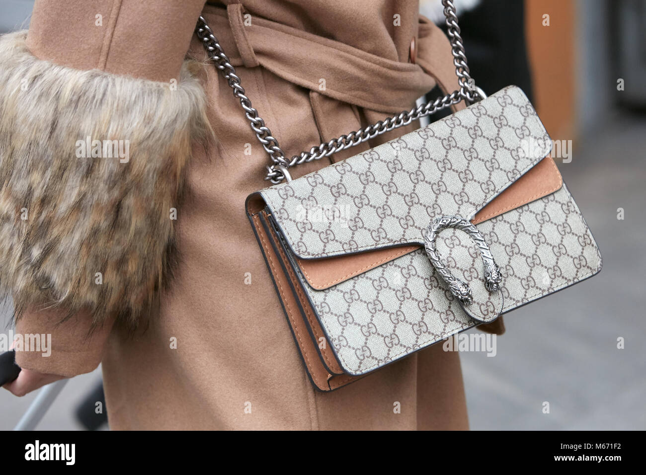 MILAN - FEBRUARY 25: Woman with Gucci bag with beige coat with fur details  before Emporio Armani fashion show, Milan Fashion Week street style on Febr  Stock Photo - Alamy