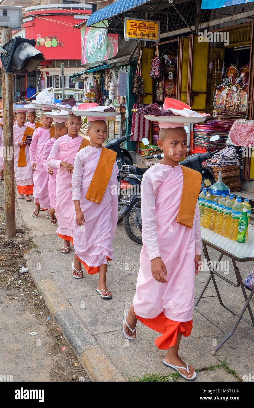 Pyin Oo Lwin, Shan State, Myanmar - June 8 2017. Young nuns balancing trays on their heads in central Pyin Oo Lwin. Stock Photo