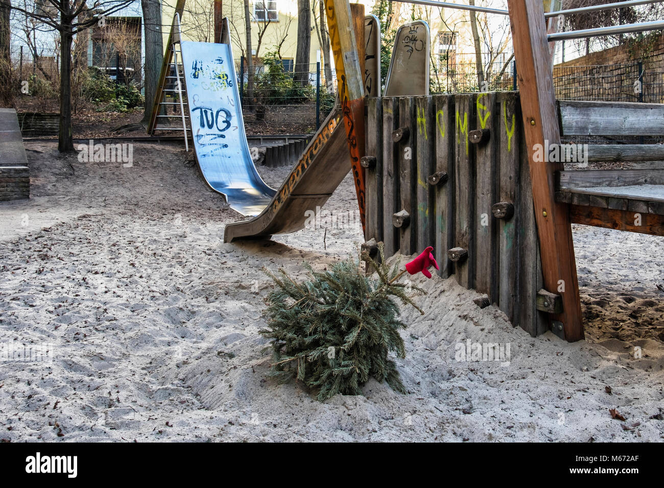 Berlin, Mitte, Old Christmas tree with red glove abandoned in sandpit of Childrens Playgound Stock Photo