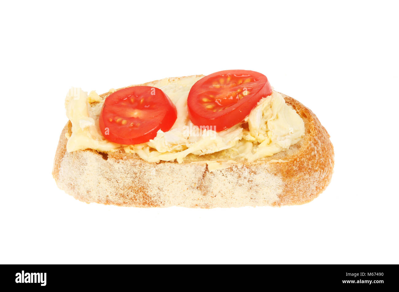 Brie cheese and tomato on rustic bread isolated against white Stock Photo