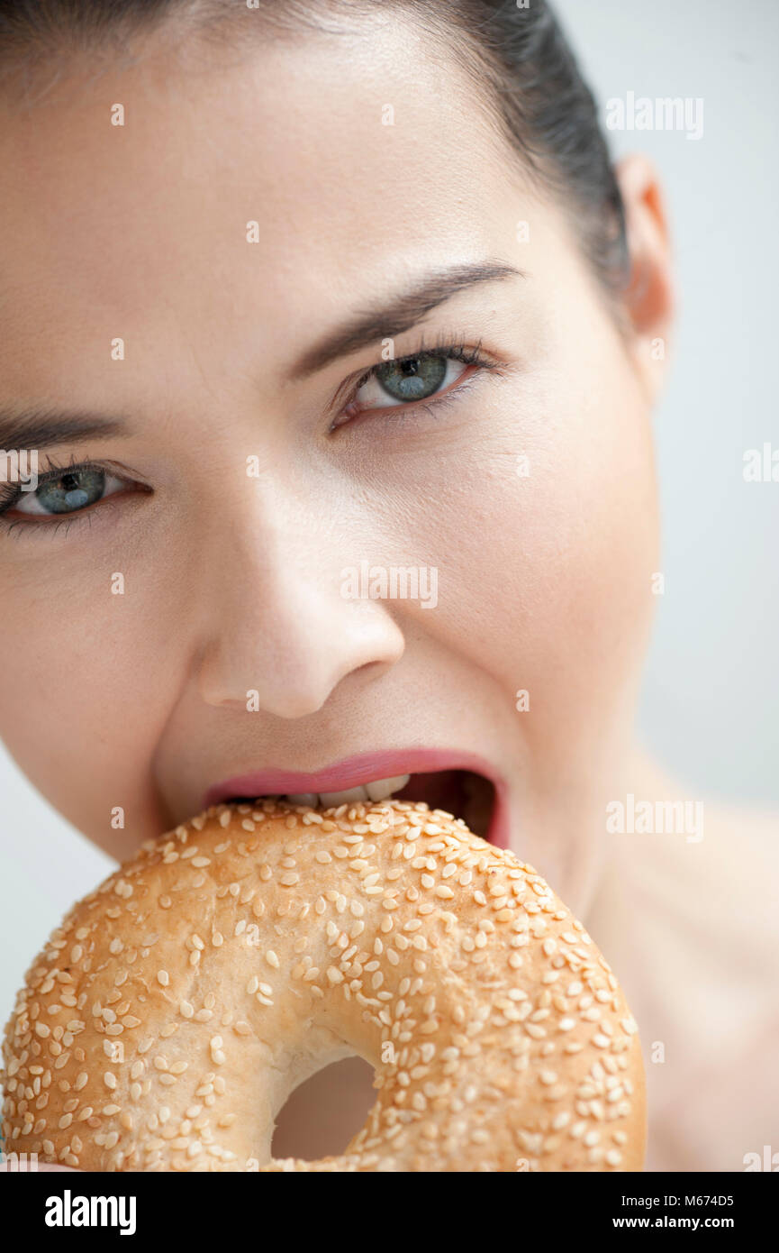 Woman with sesame seed bagel Stock Photo