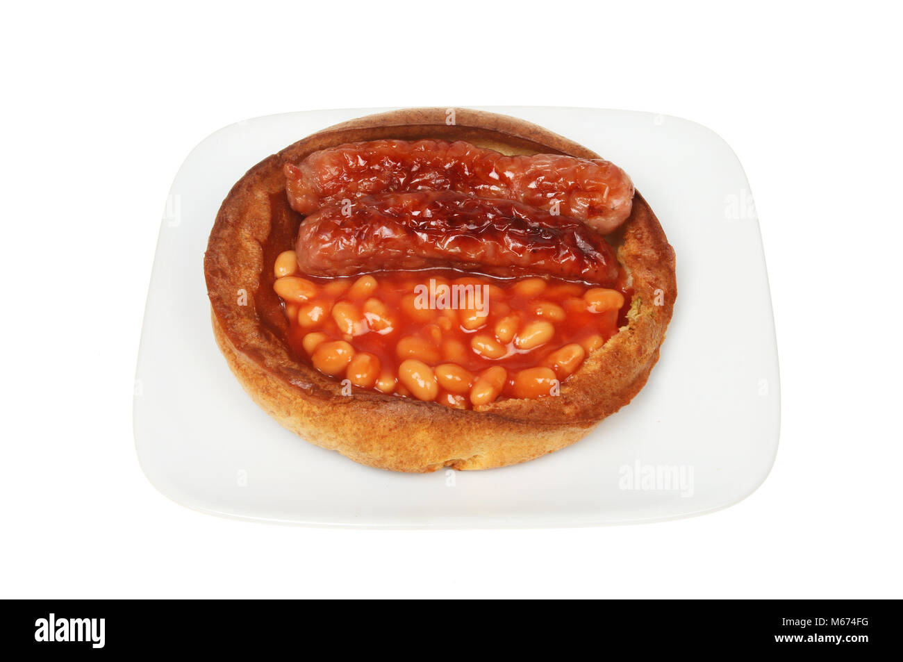 Sausages and baked beans in a giant Yorkshire pudding on a plate