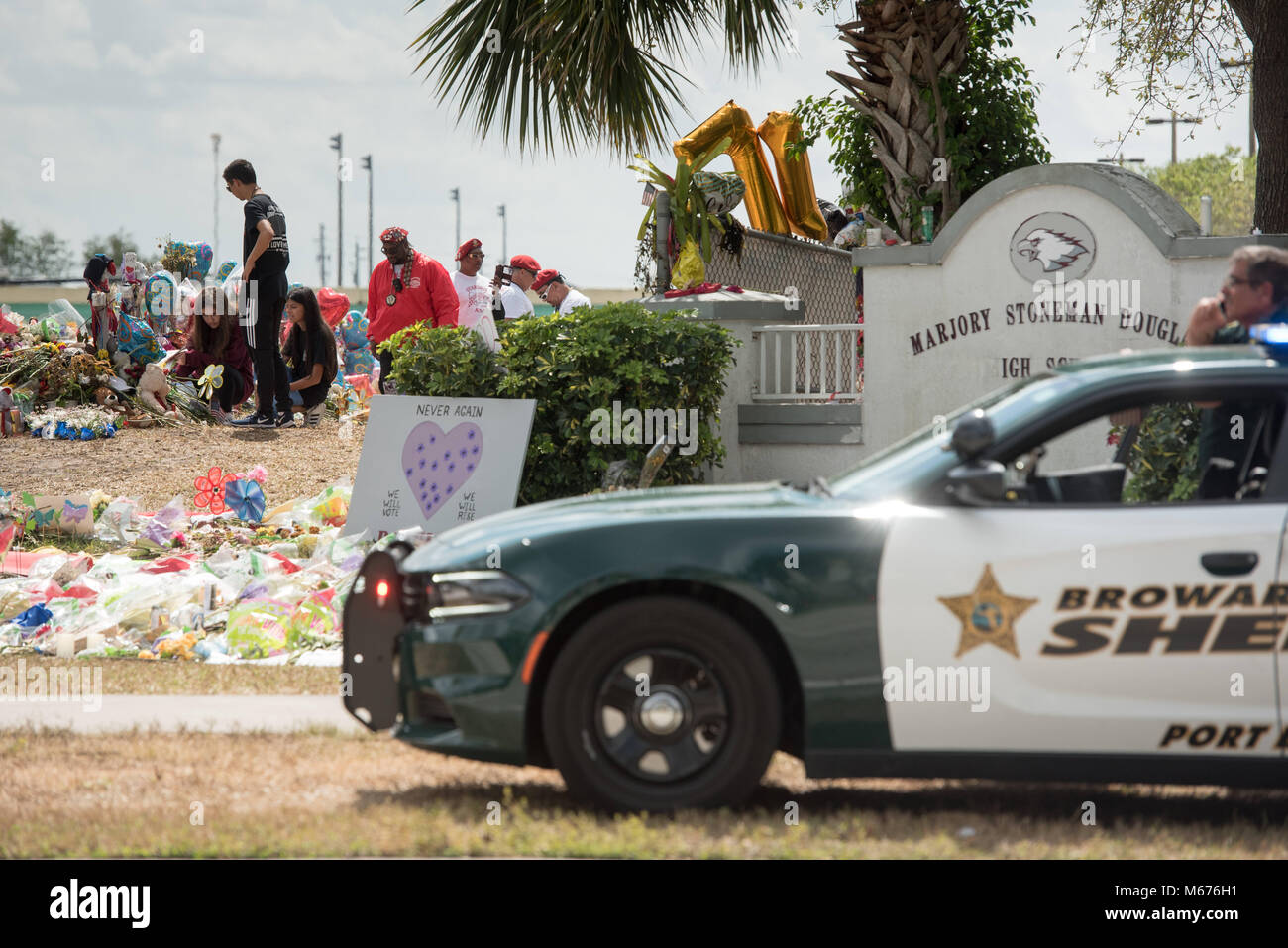 Parkland, Florida, USA. 28th Feb, 2018. Marjory Stoneman Douglas students and the Guardian Angels Safty Patrol lay flowers at the memorial for the 17 shooting victims outside of school at the end of the first day of classes since the February 14 massacre. Credit: Orit Ben-Ezzer/ZUMA Wire/Alamy Live News Stock Photo