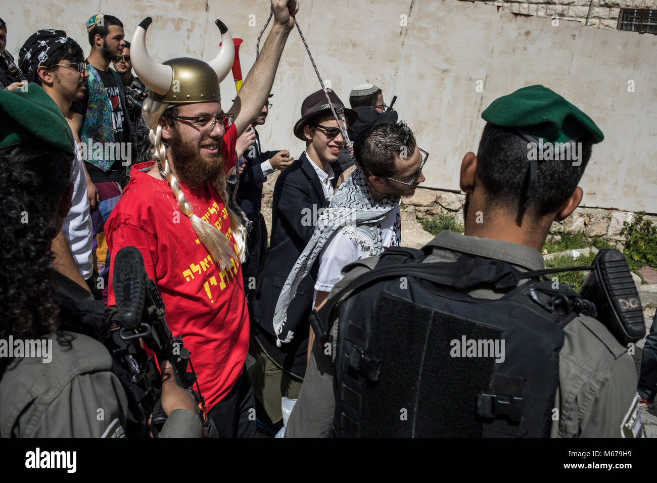 An Israeli settler wearing a Viking outfit pretends to hang a fellow settler wearing a Keffiyeh, a traditional Palestinian scarf, while taking part in a parade marking the Jewish holiday of Purim in the divided West Bank city of Hebron, 01 March 2018. The carnival-like Purim holiday is celebrated with parades and costume parties to commemorate the deliverance of the Jewish people from a plot to exterminate them in the ancient Persian empire 2,500 years ago, as recorded in the Biblical Book of Esther. Photo: Ilia Yefimovich/dpa Stock Photo