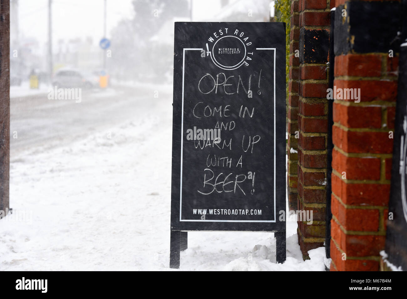 Beast from the East snow continues to be an issue in the Southend area. Micropub West Road Tap put out a humorous message to passers-by to warm up with a beer Stock Photo