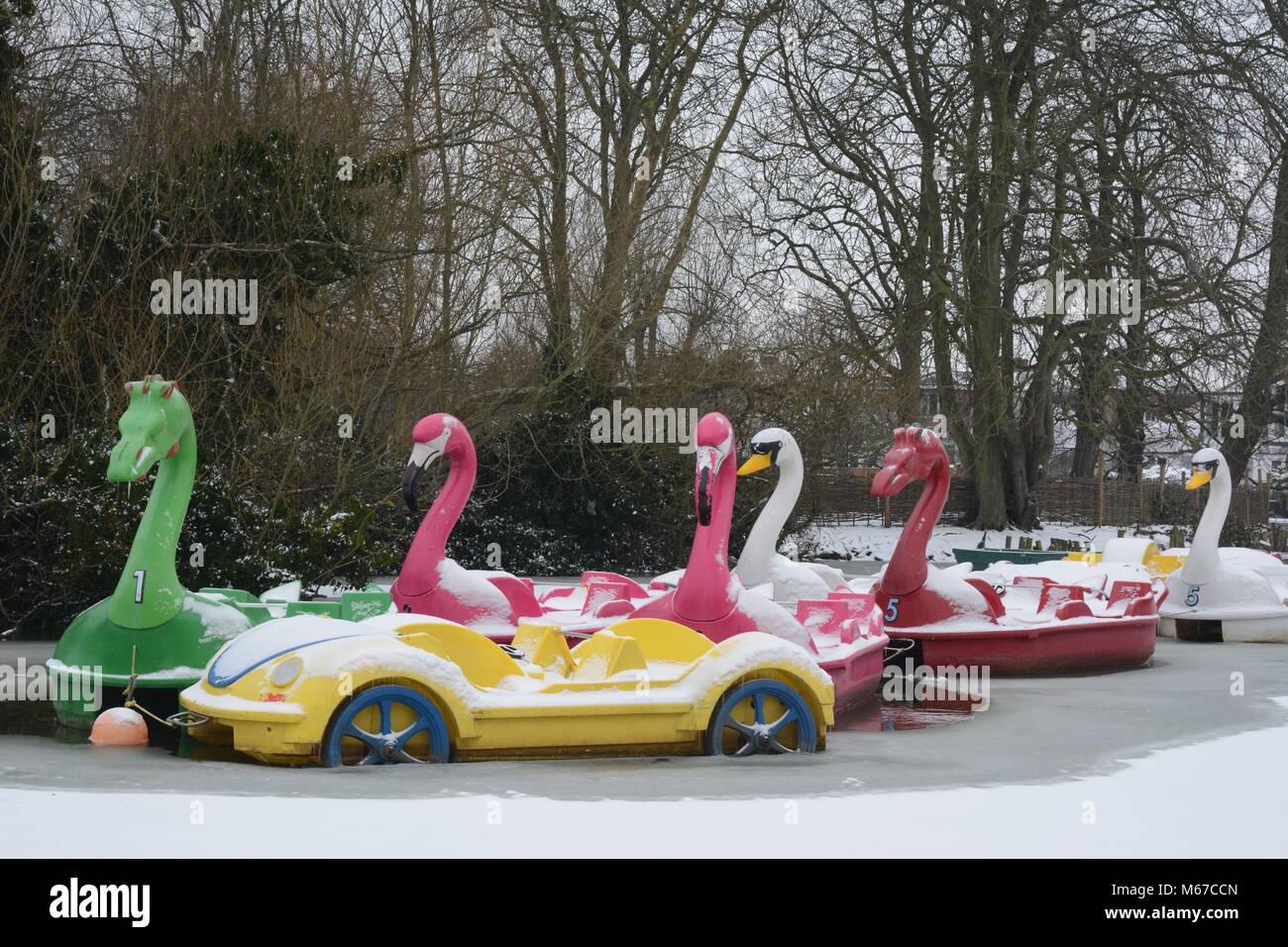 Novelty pedalos in the shape of cars, swans, dragons and flamingos are frozen in during a winter cold snap at Alexandra Palace Park, London, UK Stock Photo