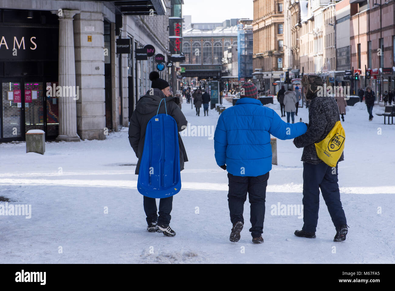 Glasgow, Scotland, UK. 1st March, 2018. Pedestrians in Glasgow city centre carrying sledge as Beast from the East weather front hits Credit: Tony Clerkson/Alamy Live News Stock Photo