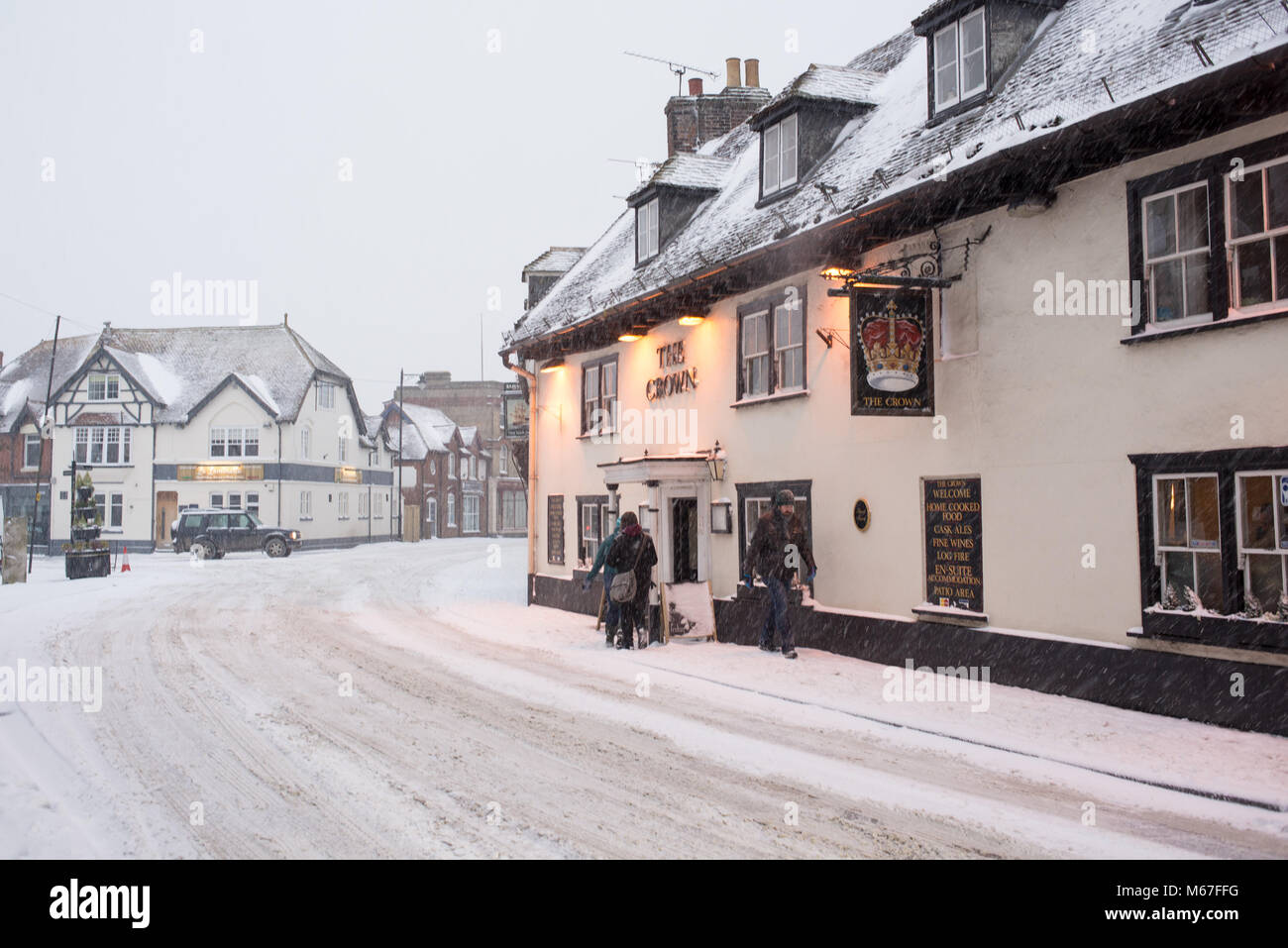 The Crown pub on snow covered Fordingbridge High Street, New Forest, Hampshire, England, UK