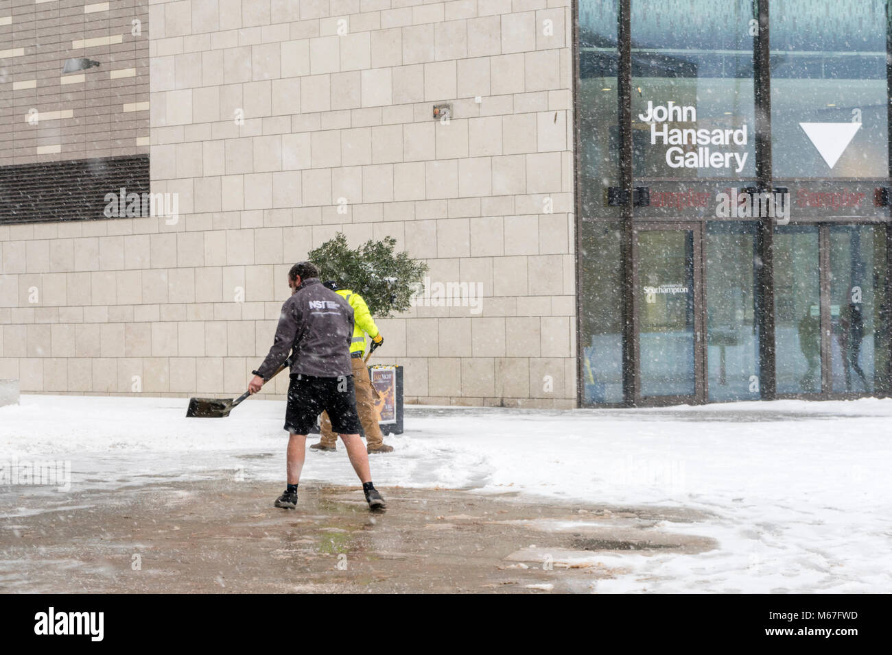 Southampton, UK. 1st of March 2018. Staff from Studio 144 in Southampton city centre, Hampshire, England,  are gritting the pavement during heavy snowfall during the 'Beast from the East' adverse weather conditions. Stock Photo