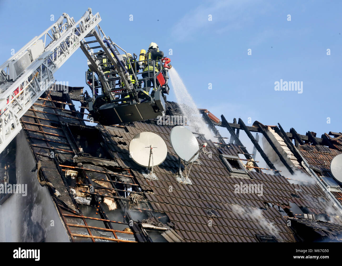 01 March 2018, Germany, Gelsenkirchen: Firefighters extinguish the attic fire in a multiple family dwelling. Several people were injured, one person is still missing. Photo: Roland Weihrauch/dpa Stock Photo