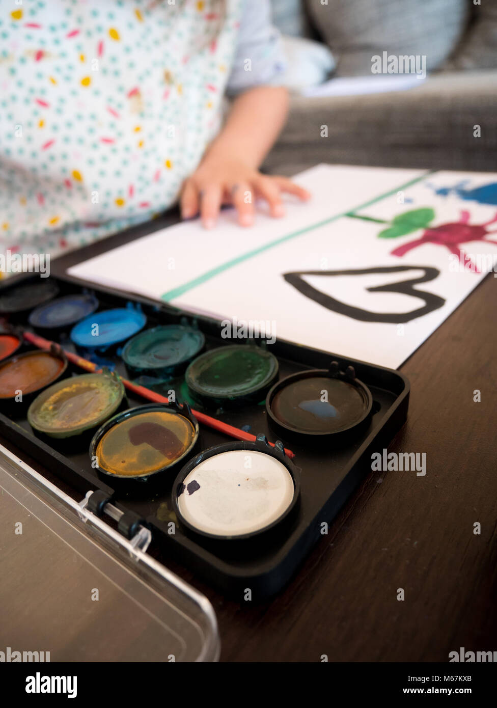 Small kid painting with watercolors at home Stock Photo - Alamy