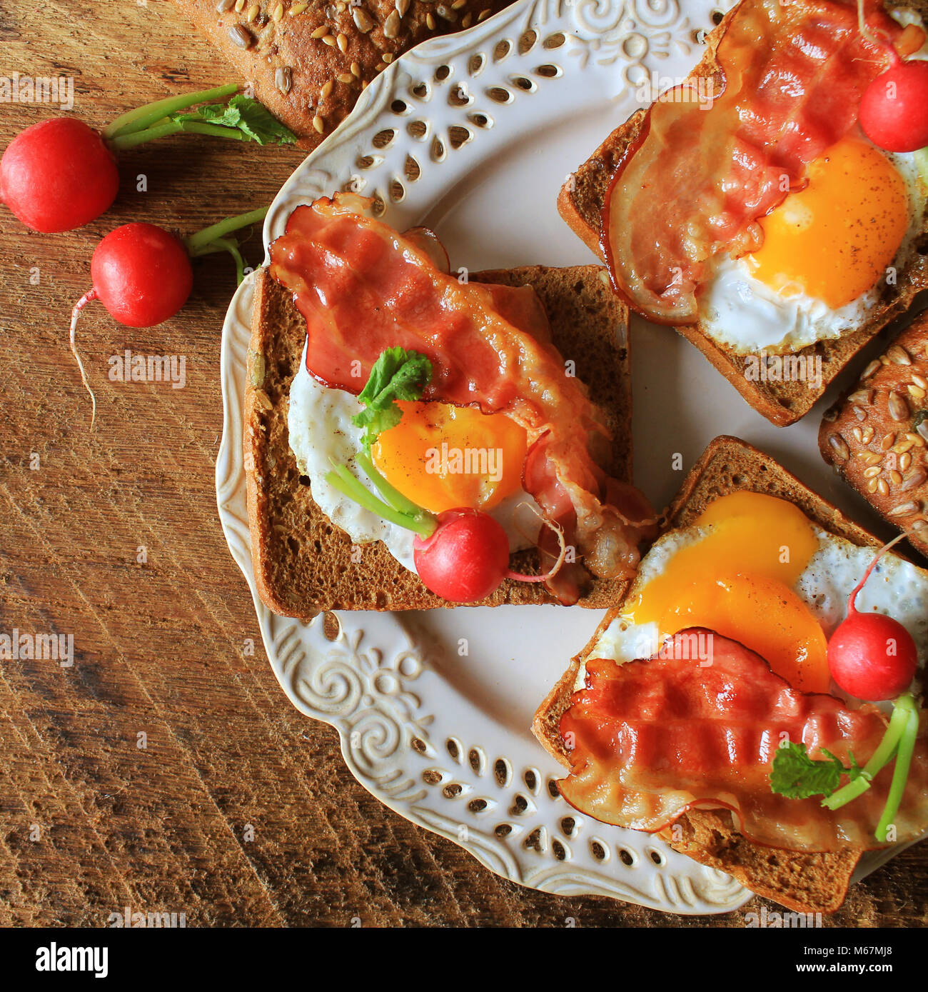 Breakfast , crispy bacon, fried eggs and bread. Sandwiches on white