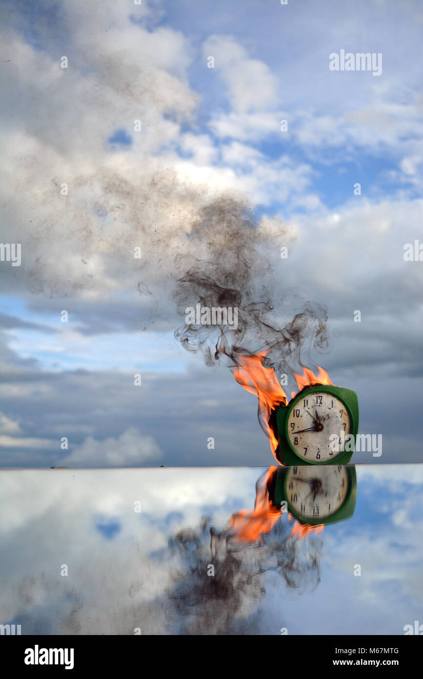 Burning old green analogue clock on mirror on sky background, end of time Stock Photo Alamy