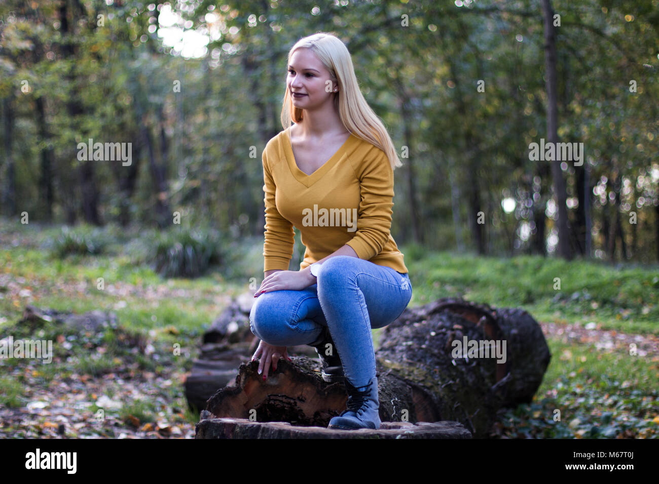 Young and beautiful blonde woman in the forest, enjoying nature. Stock Photo