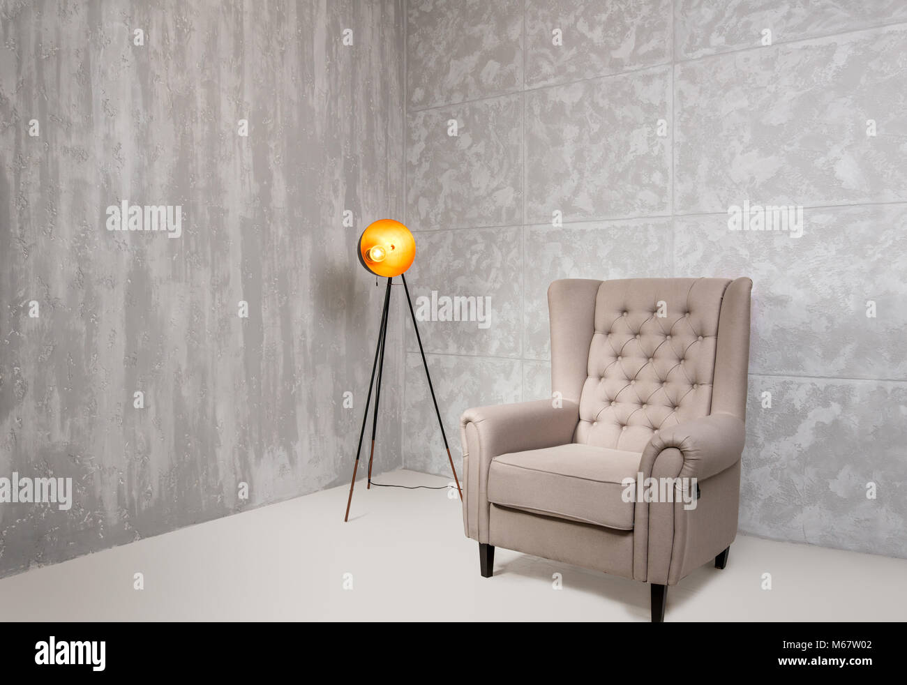 Gray interior with armchair and lamp Stock Photo - Alamy