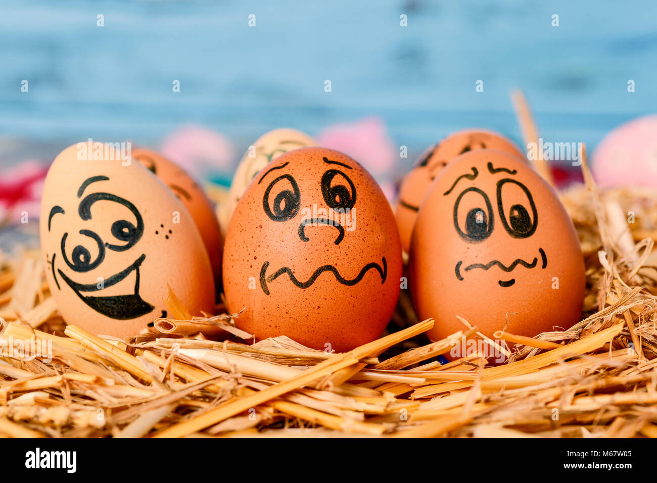 Closeup Of Some Brown Different Eggs With Funny Faces On A Pile Straw