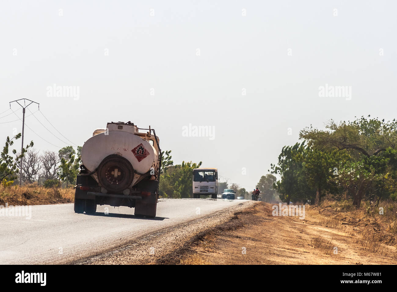 Fuel truck and traffic on the State Road 1 heading to Bobo-Dioulasso, Burkina Faso. Stock Photo