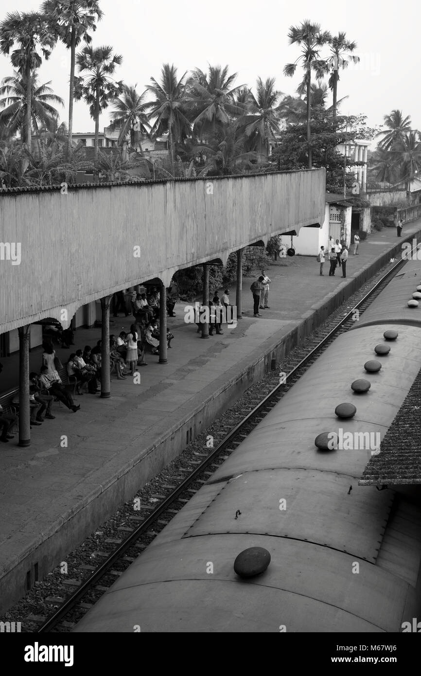 People wait on the railway platform at Mount Lavinia station near