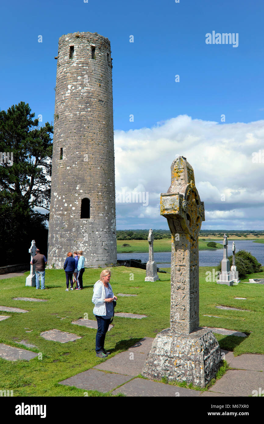 Woman standing next to the Cross of the Scriptures, Clonmacnoise Monastery, County Offaly, Ireland Stock Photo