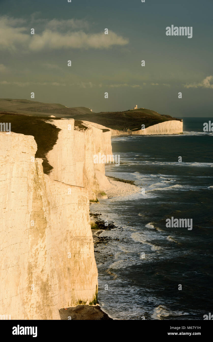 The cliffs of Seven Sisters with Belle Tout lighthouse in the background, on the Sussex coast on the South Downs Way. Stock Photo