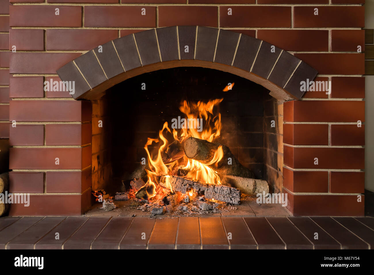 Firewood and hot coals burn in a brick fireplace with bright fire Stock Photo Alamy
