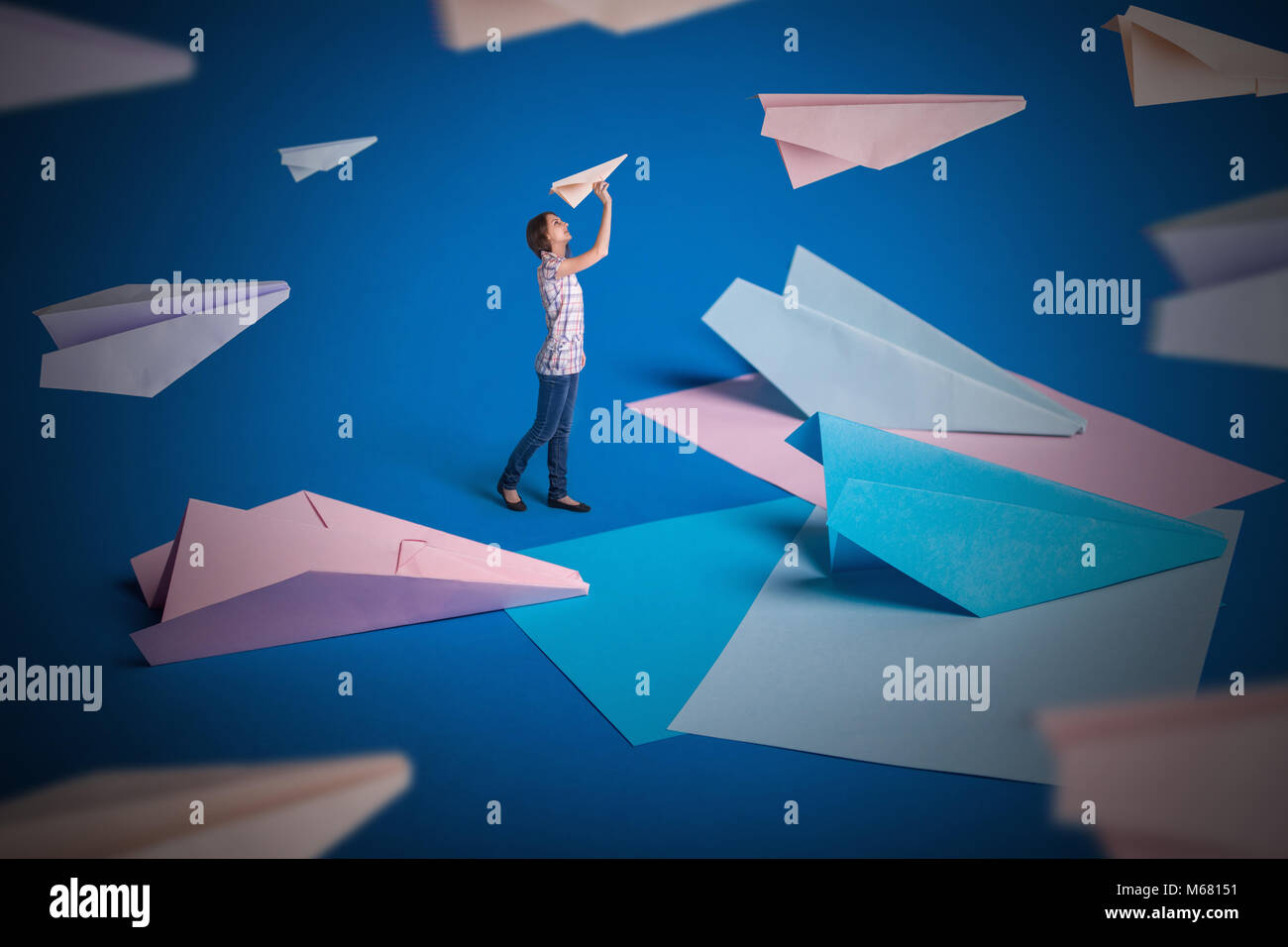 Creative surrealism design with origami paper planes. Girl let paper airplanes Stock Photo