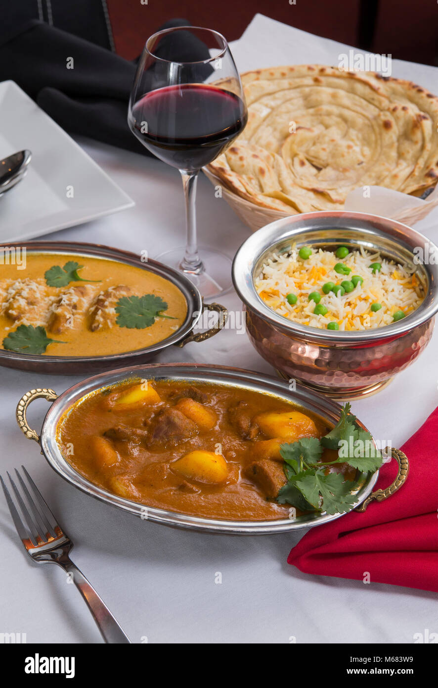 Indian curry food spread on a fancy dinner table with rice, laccha