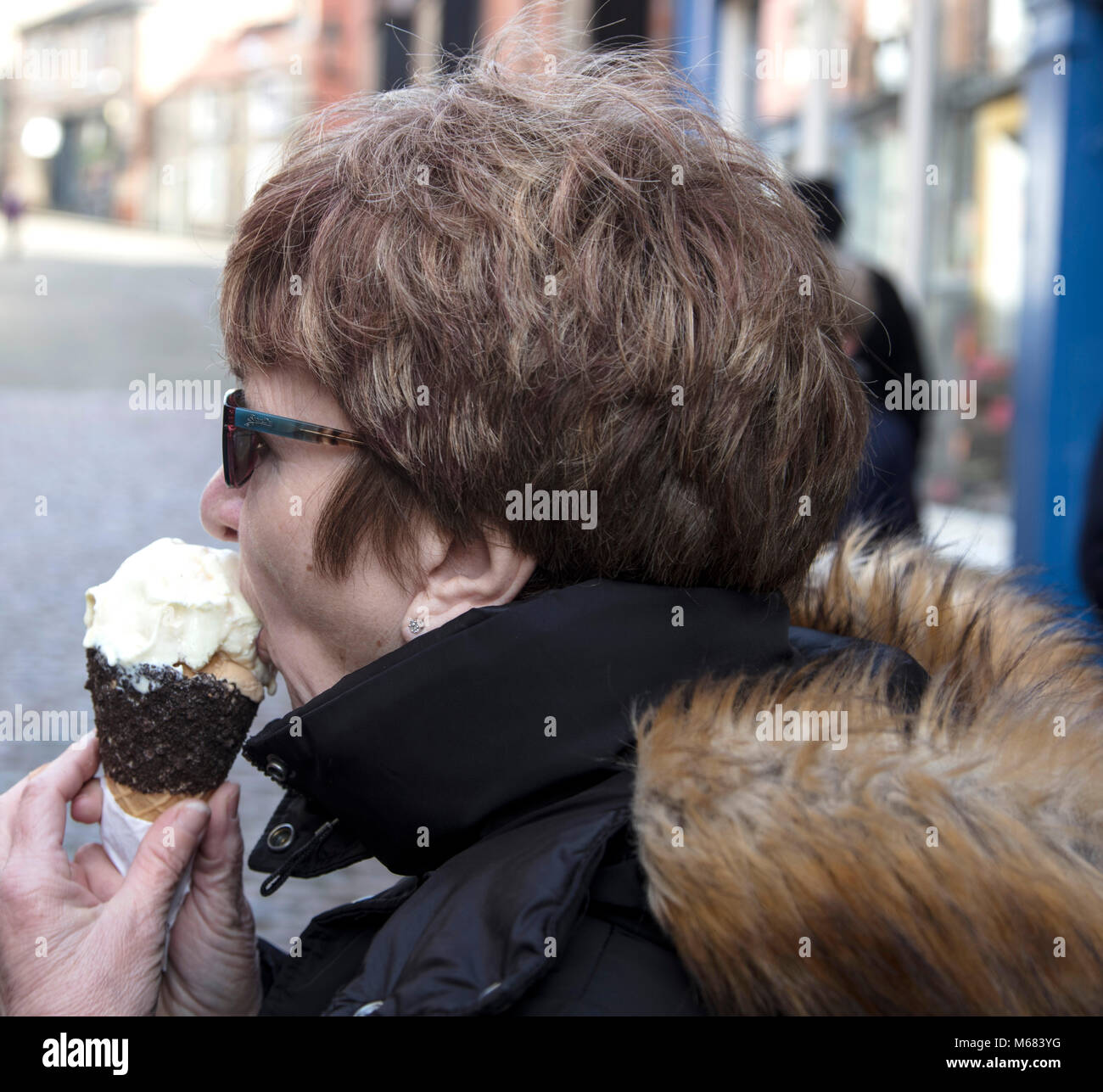Lady eating ice cream cone in winter Stock Photo Alamy