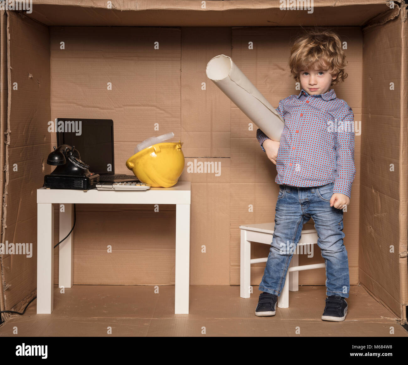 sad face of a small engineer, plans for building in hand Stock Photo ...