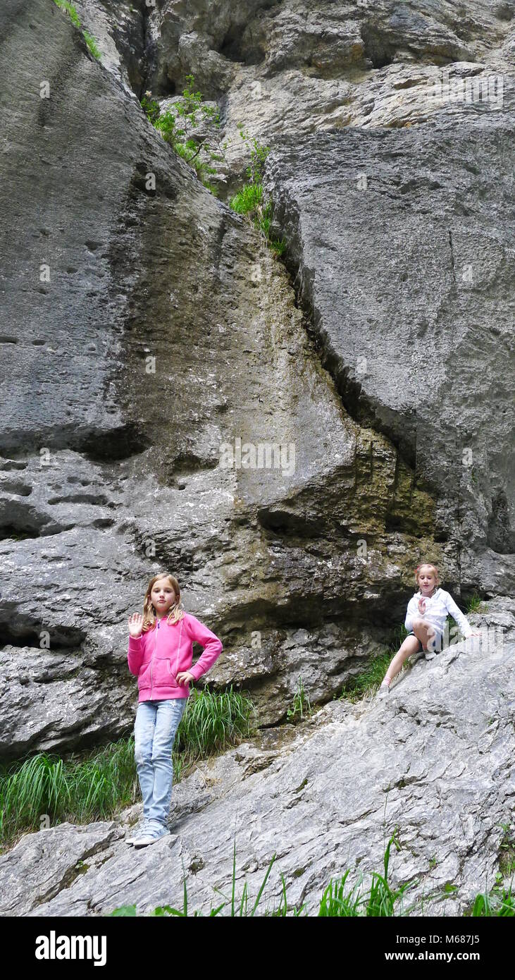 Kids rock climbing on a rocky face at  Aareschlucht, Meiringen Switzerland Stock Photo