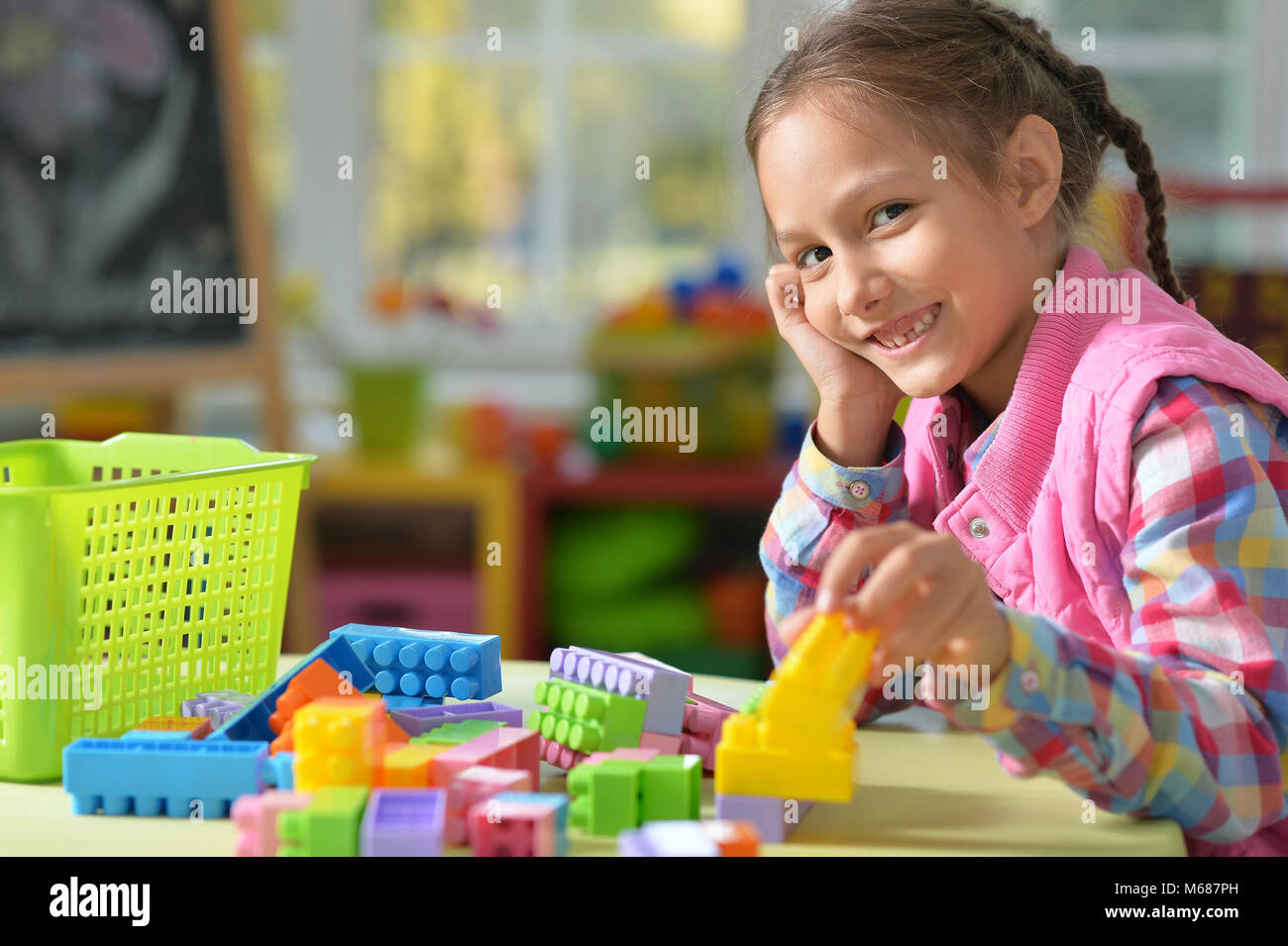 girl playing with colorful plastic blocks Stock Photo - Alamy