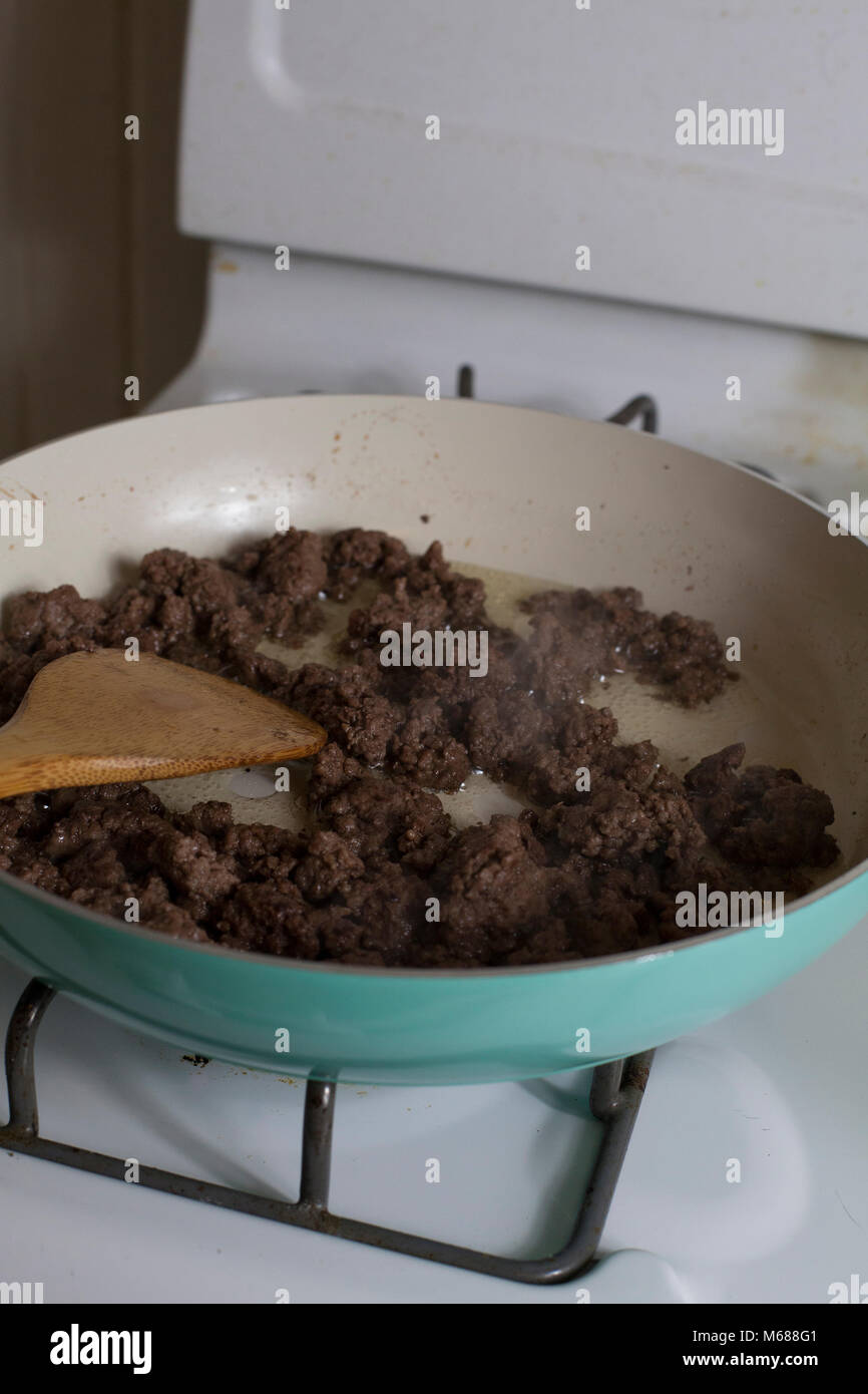 Cooked ground beef and a stirring spoon in a frying pan Stock Photo