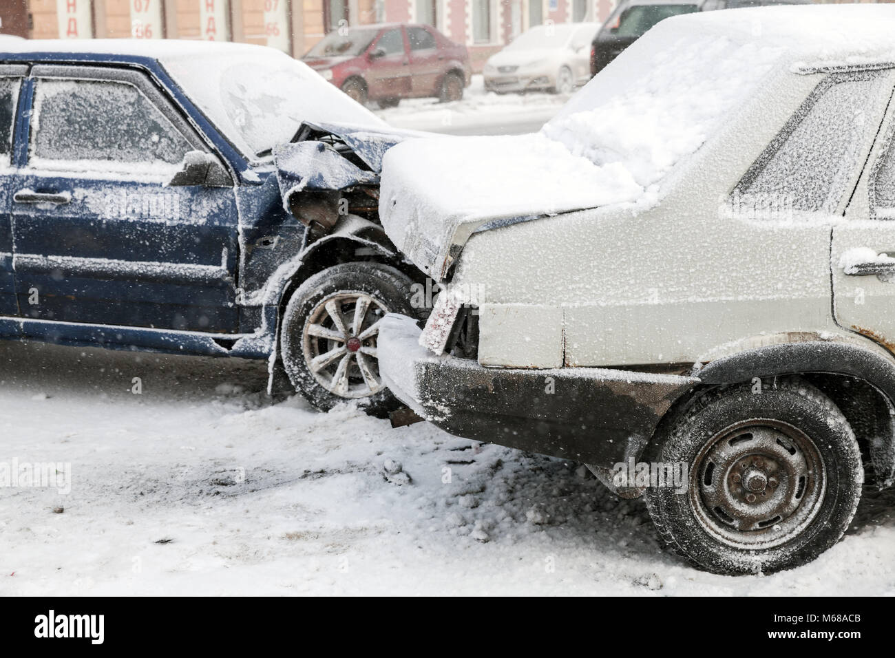 Two crashed cars in accident on winter street with snow Stock Photo