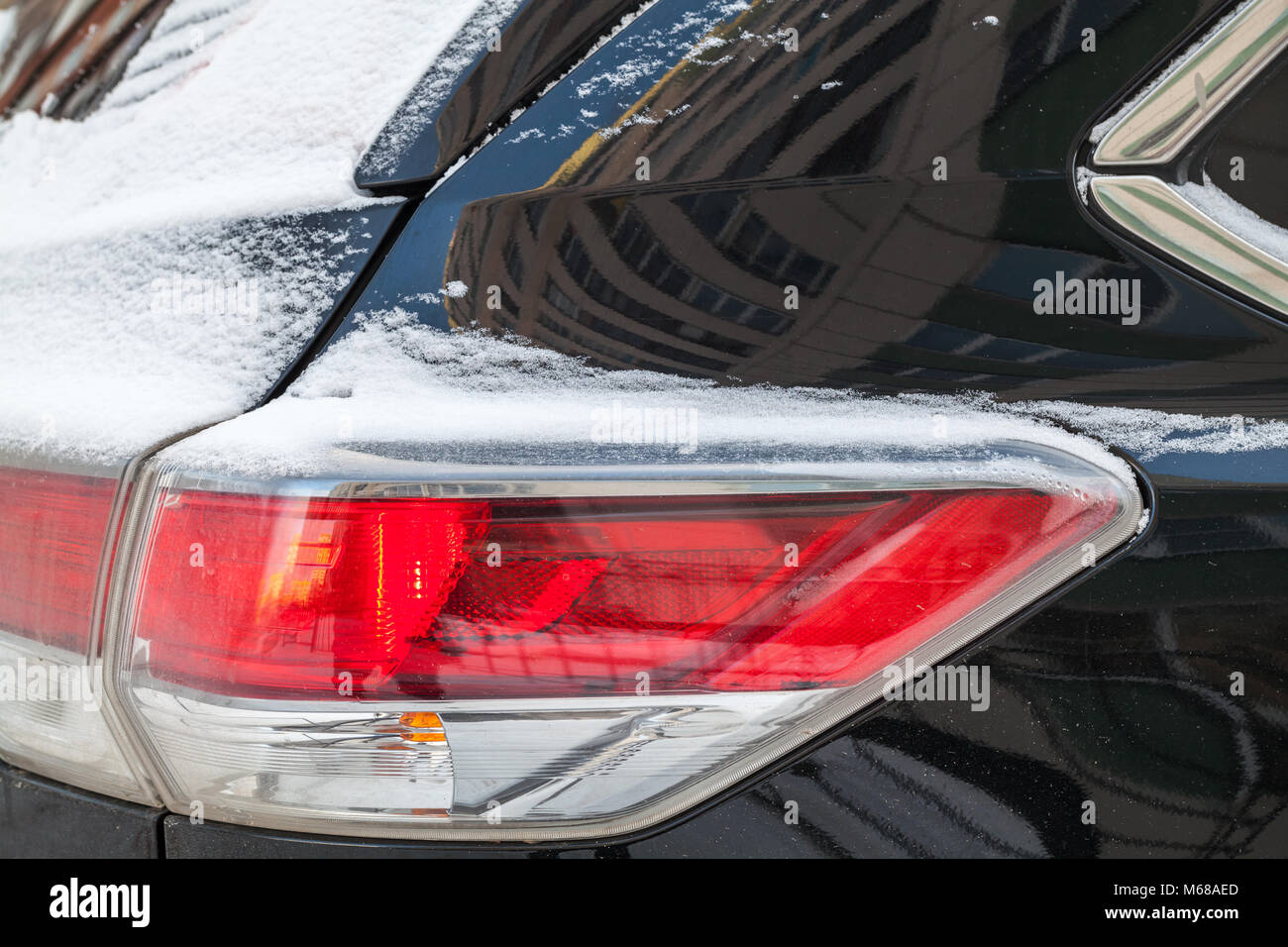 Rear stop lights of SUV car covered with snow, winter season Stock Photo
