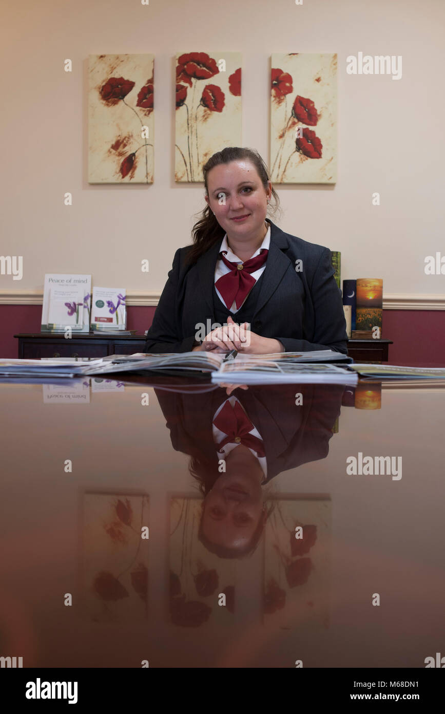a female member of staff at an undertakers helps to plan a funeral with all the arrangements Stock Photo