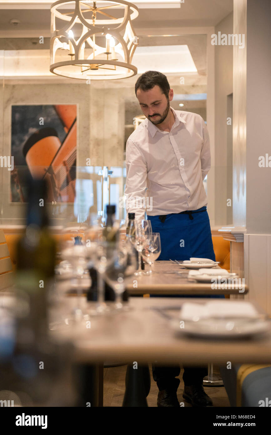 a male waiting staff working at a restaurant Stock Photo Alamy
